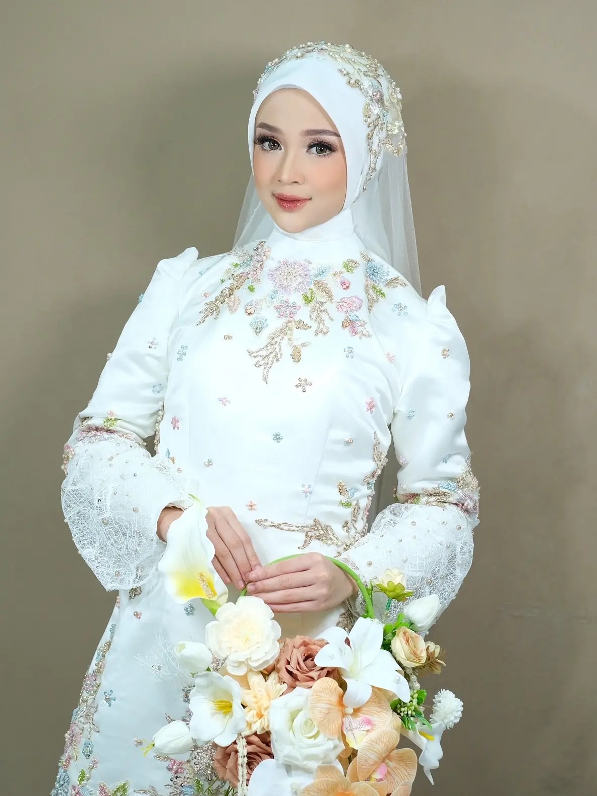 Busana akad putih dengan bordir bunga dan buket