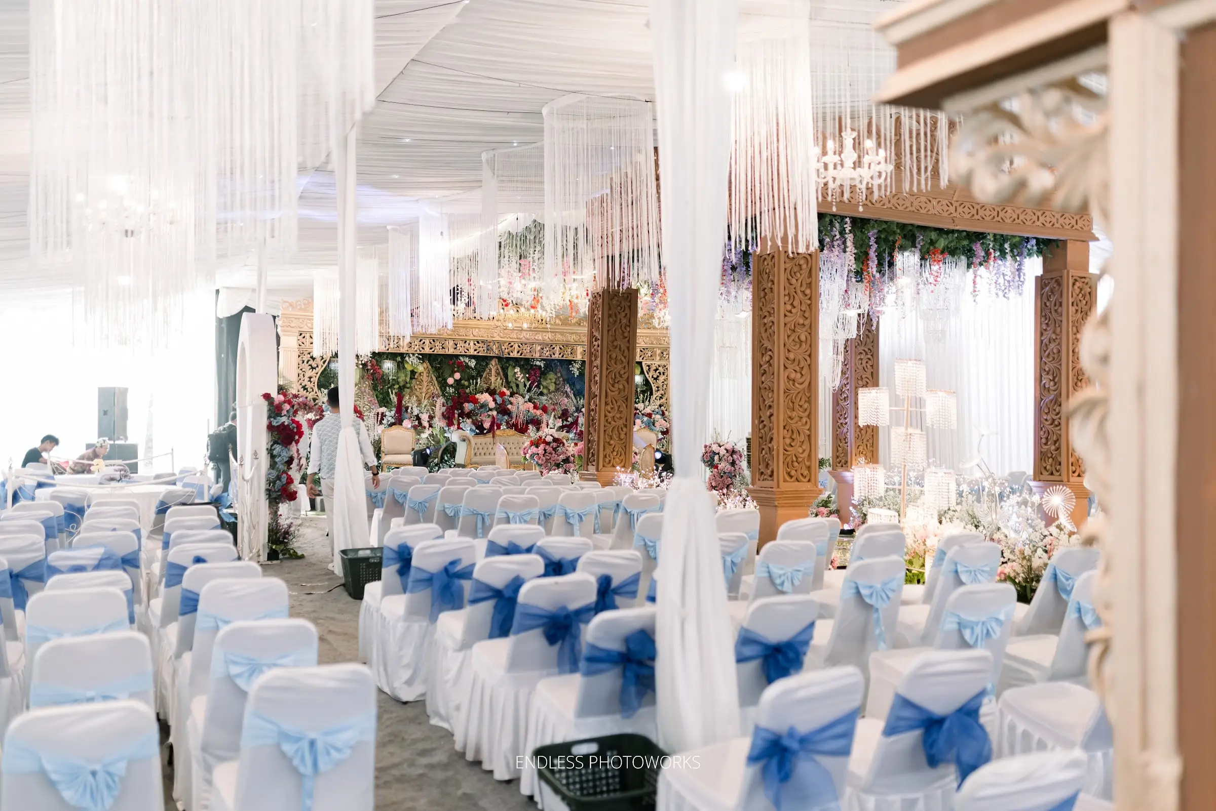 Ruang resepsi dengan kursi tamu berpita biru dan tirai kristal