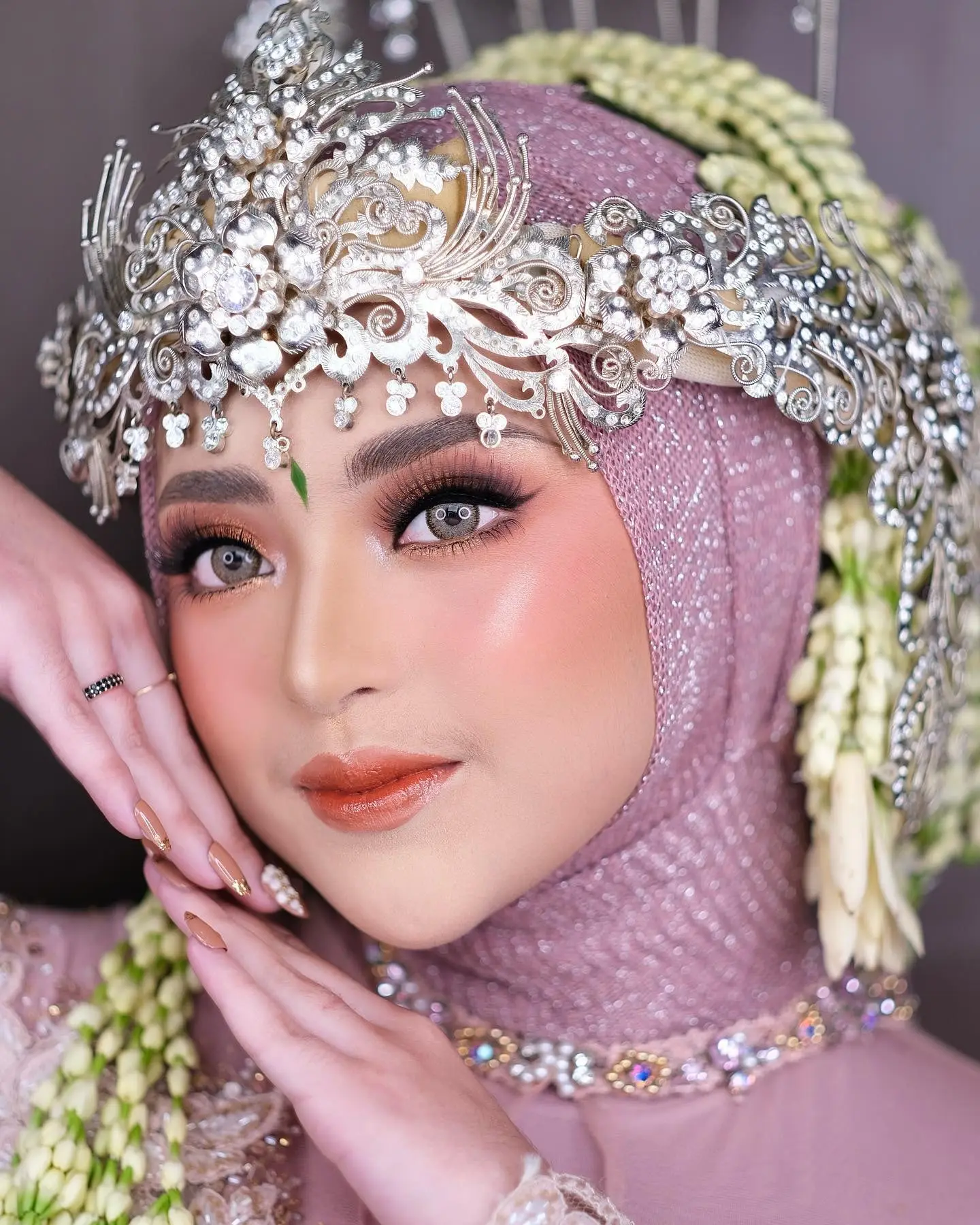 Rias pengantin dengan siger perak dan hijab ungu muda